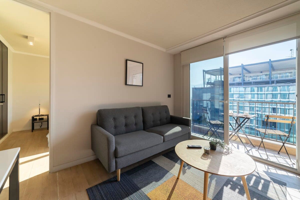 Cozy living area with natural light and a charming balcony, perfect for relaxing in the heart of the city.