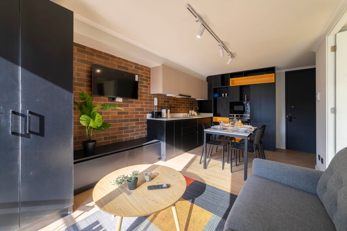 Experience modern living in this stylish studio with a sleek kitchen, cozy seating, and vibrant decor.