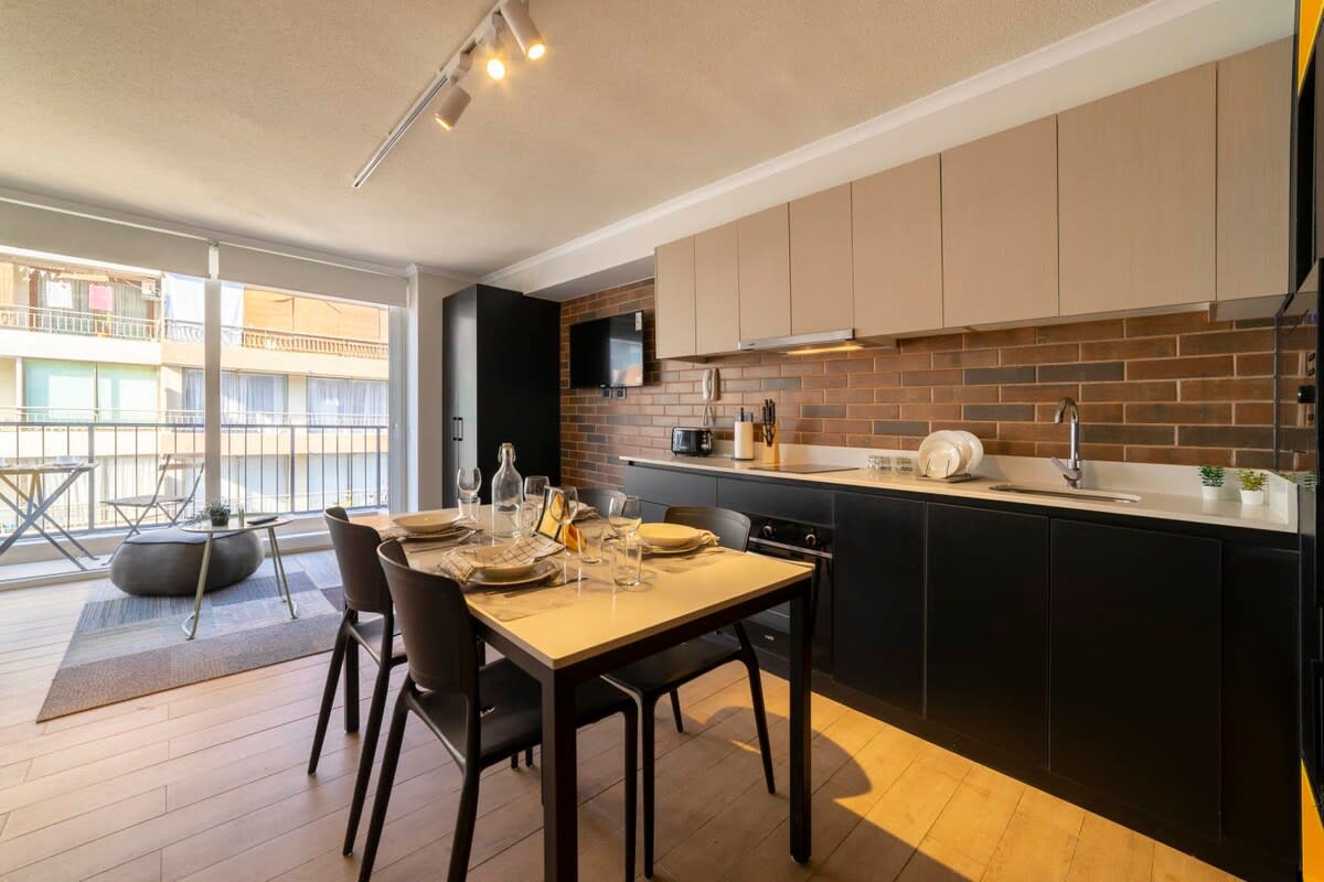 Enjoy cooking in this stylish kitchen with a cozy dining area and a view of the balcony.