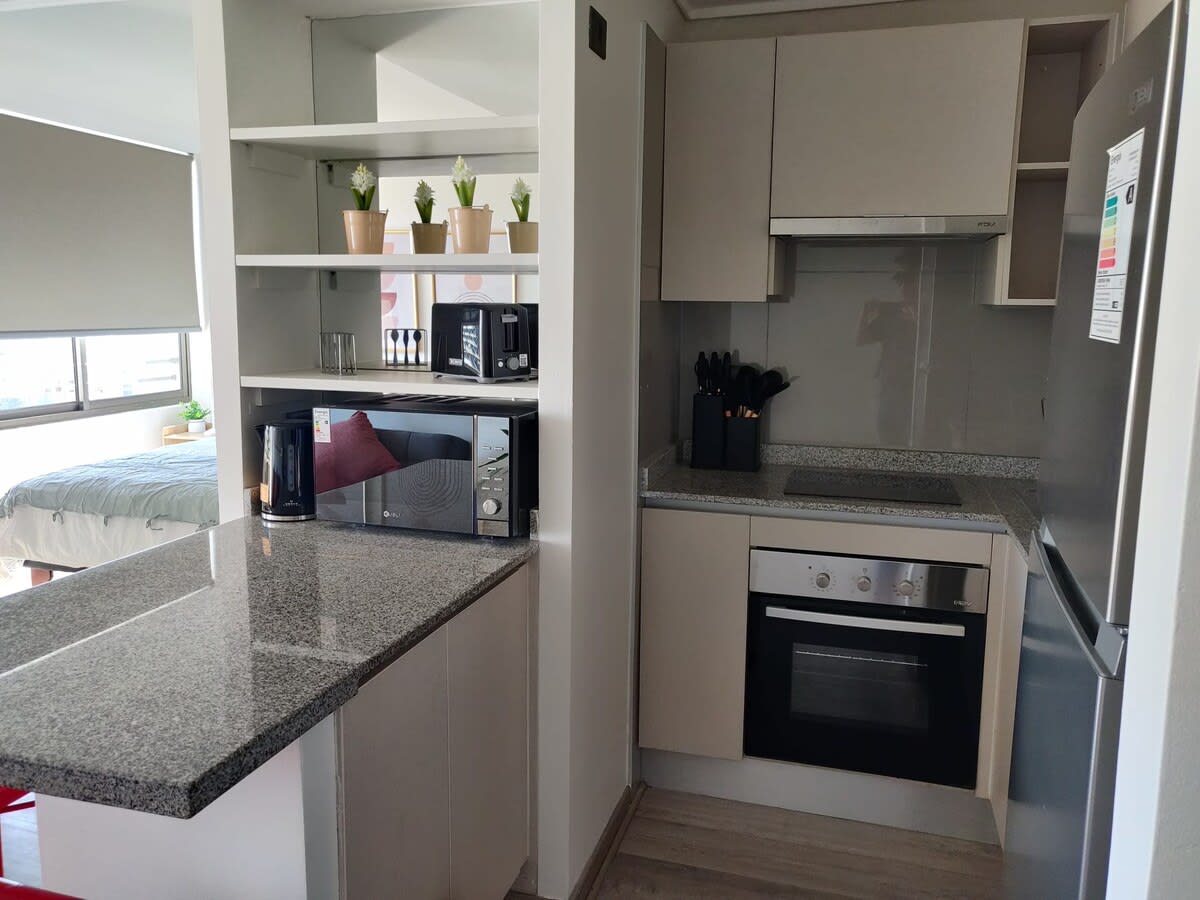 Modern kitchen with granite countertops and all essentials for a comfortable stay. Cocina Totalmente Equipada