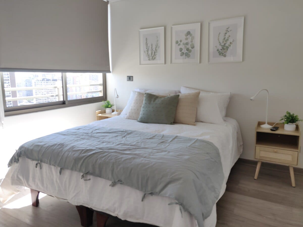 Relax in this cozy bedroom with city views, perfect for unwinding after a day of exploring Santiago.