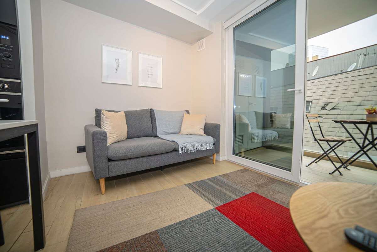 Relax in this inviting living area with a comfy sofa and enjoy the charming balcony view, perfect for unwinding after a day of exploring.