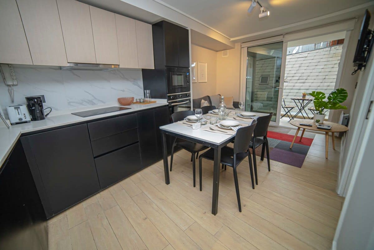 Modern kitchen and dining area with patio access, perfect for cozy meals and relaxation.