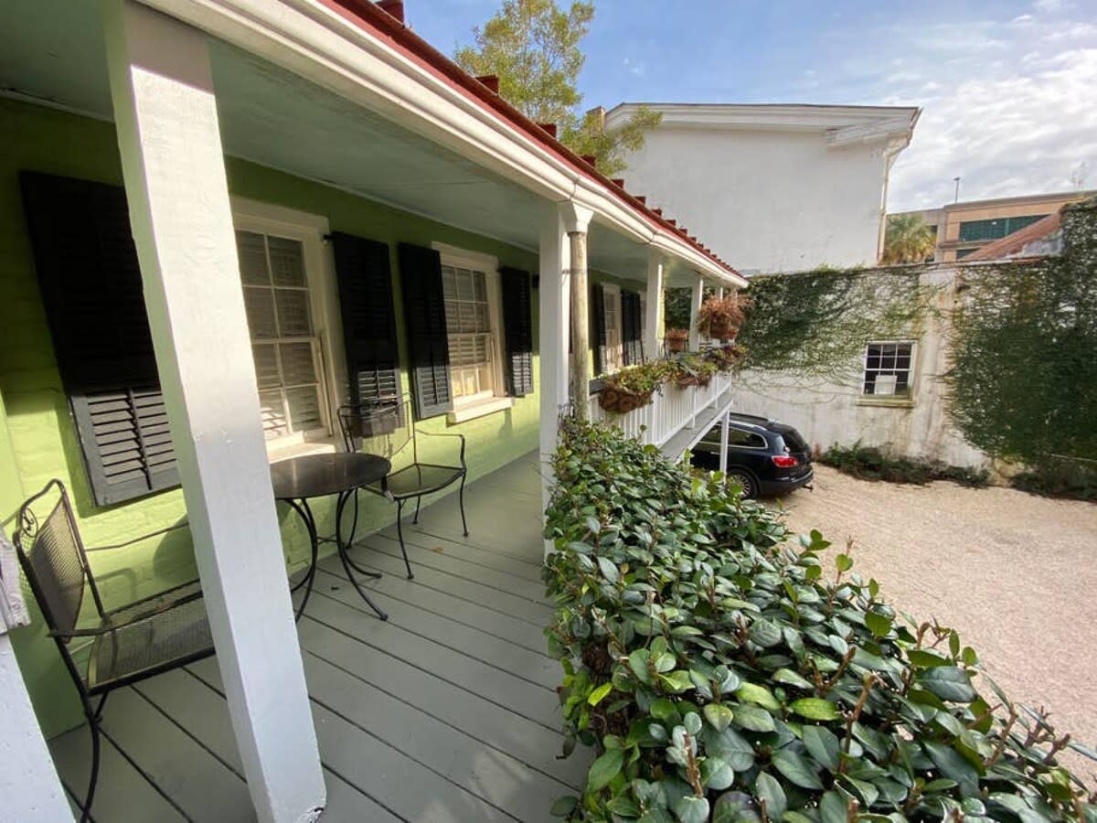 Porch seating on the back end of the house where the unit is, off street parking below.