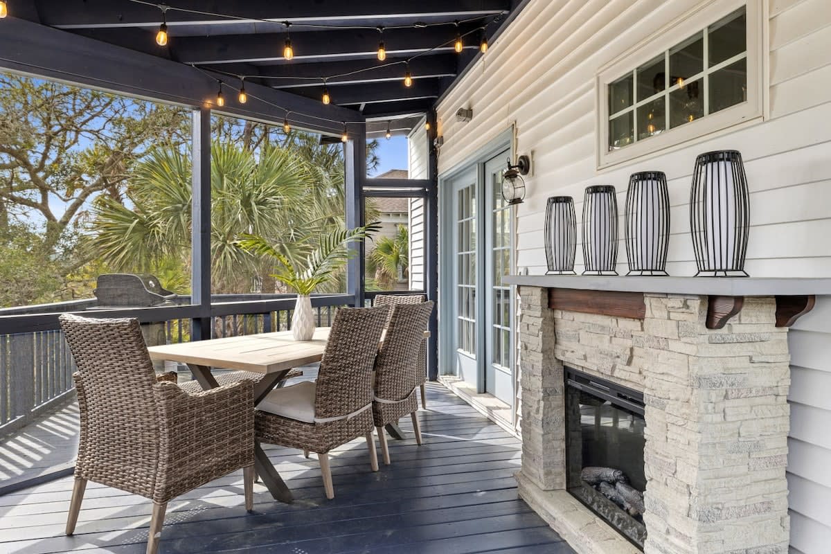 Screened in outdoor seating area with a grill