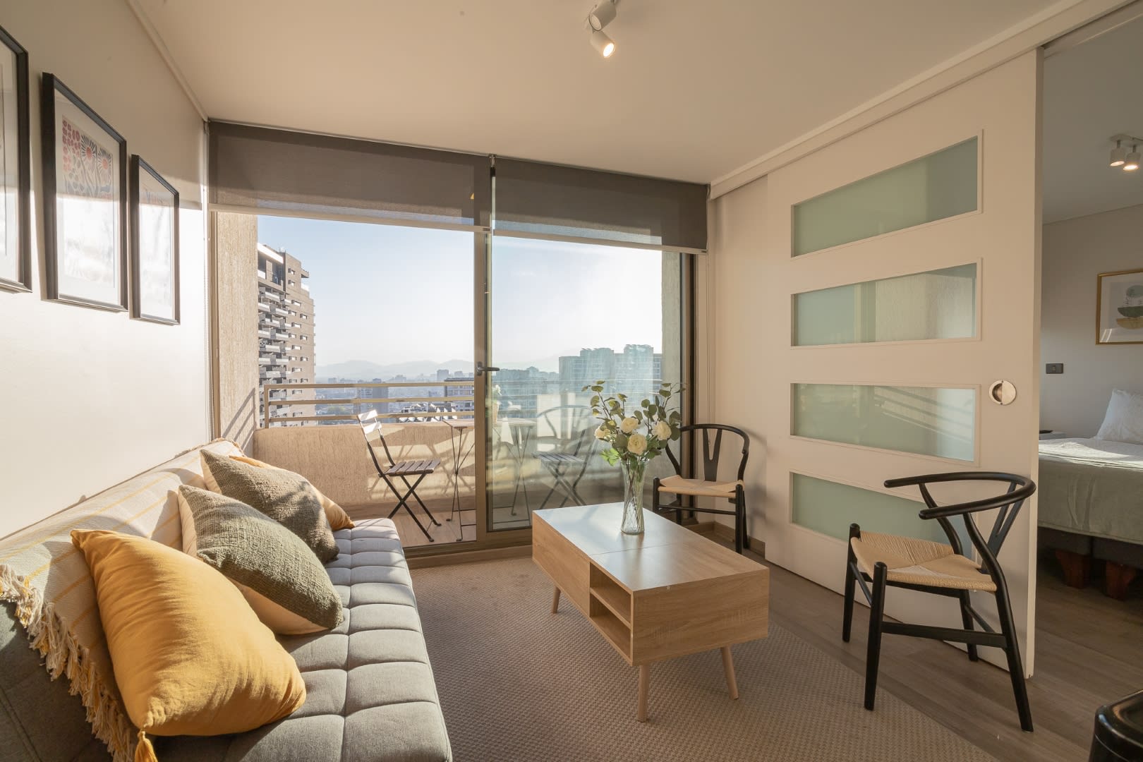 Bright and cozy living area with balcony access and stunning city views, perfect for relaxation.