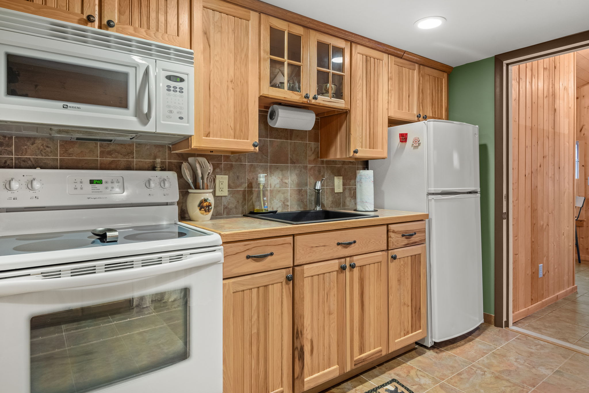 A bright and functional kitchen with ample counter space, white appliances, and classic wood cabinetry.