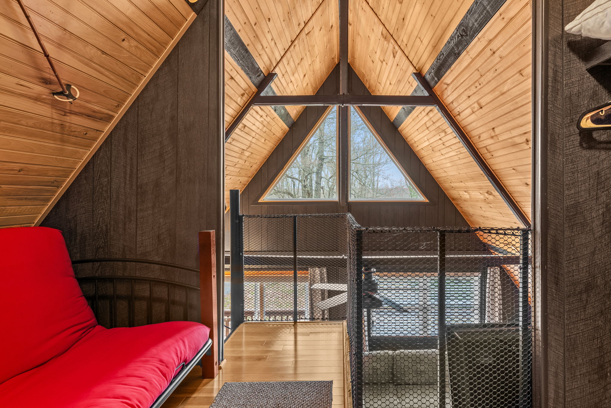 Stunning A-frame loft with large windows and a beautiful outdoor view.