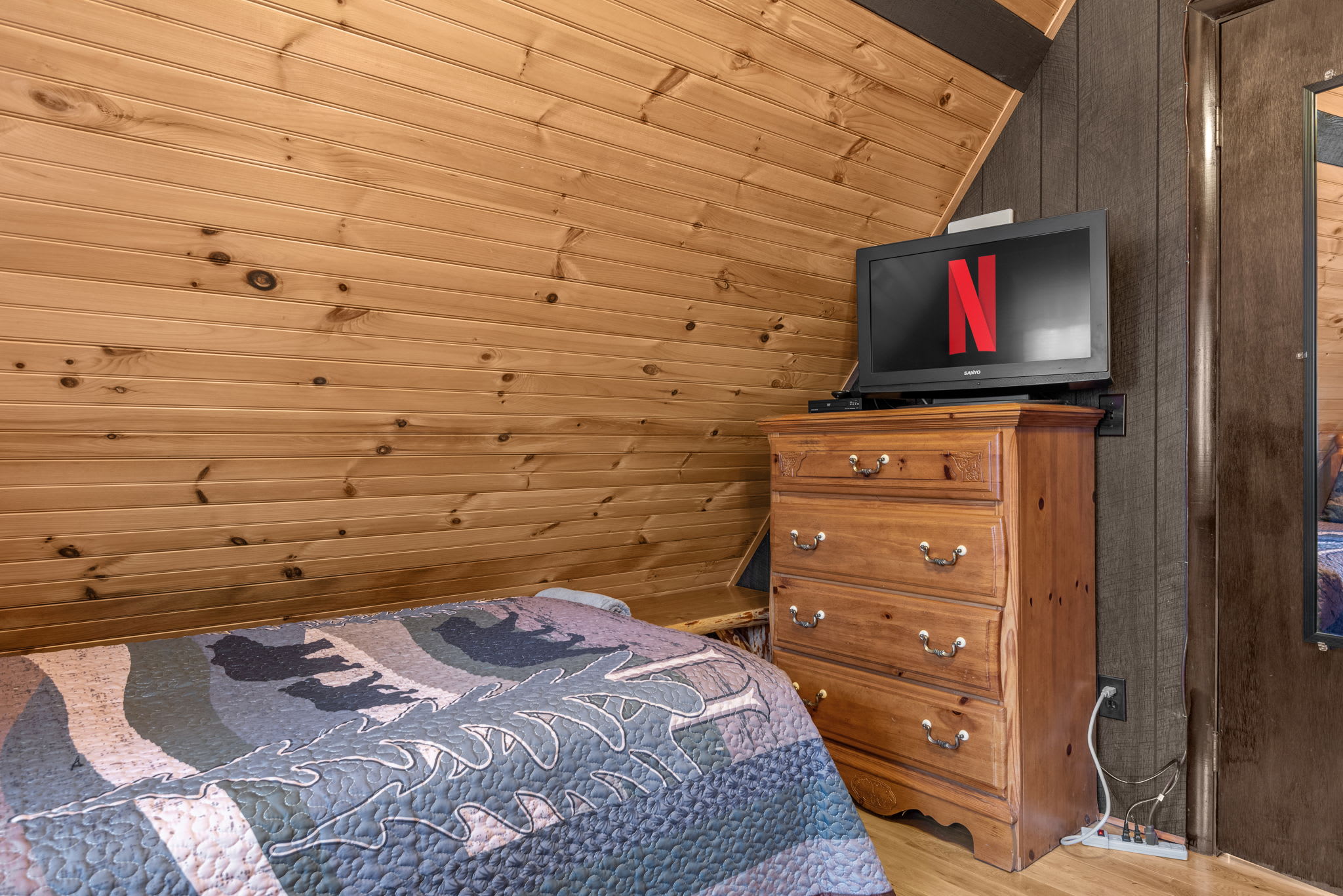 Enjoy entertainment with a flat-screen TV and Netflix, set atop a rustic wooden dresser.