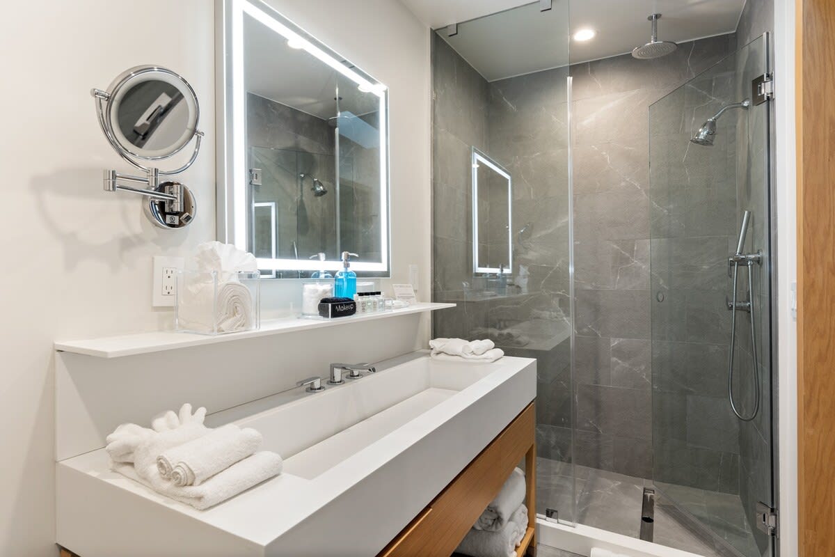 Glass framed showers with a Graff rain shower. Luxurious finishes include Toto Neorest 700 Dual Flush Bidet. Perfectly lit LED vanity.