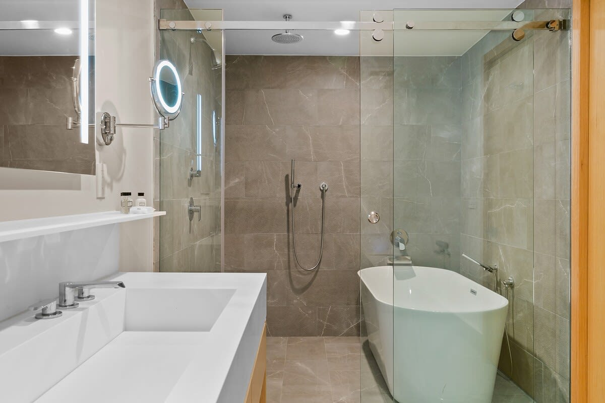 Luxurious bathroom equipped with LED mirrored lighting, a walk in shower and a deep soaking tub