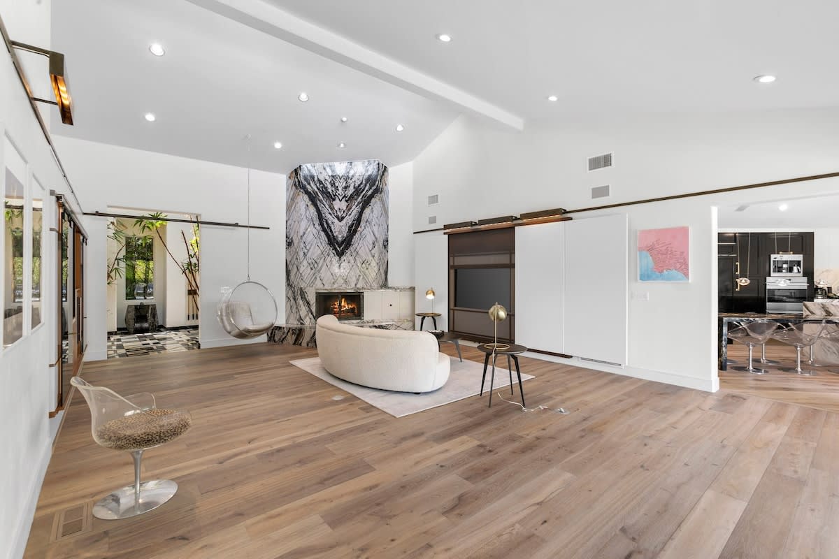 The expansive living room boasts an impressive book matched marble fireplace, smart tv and sound system