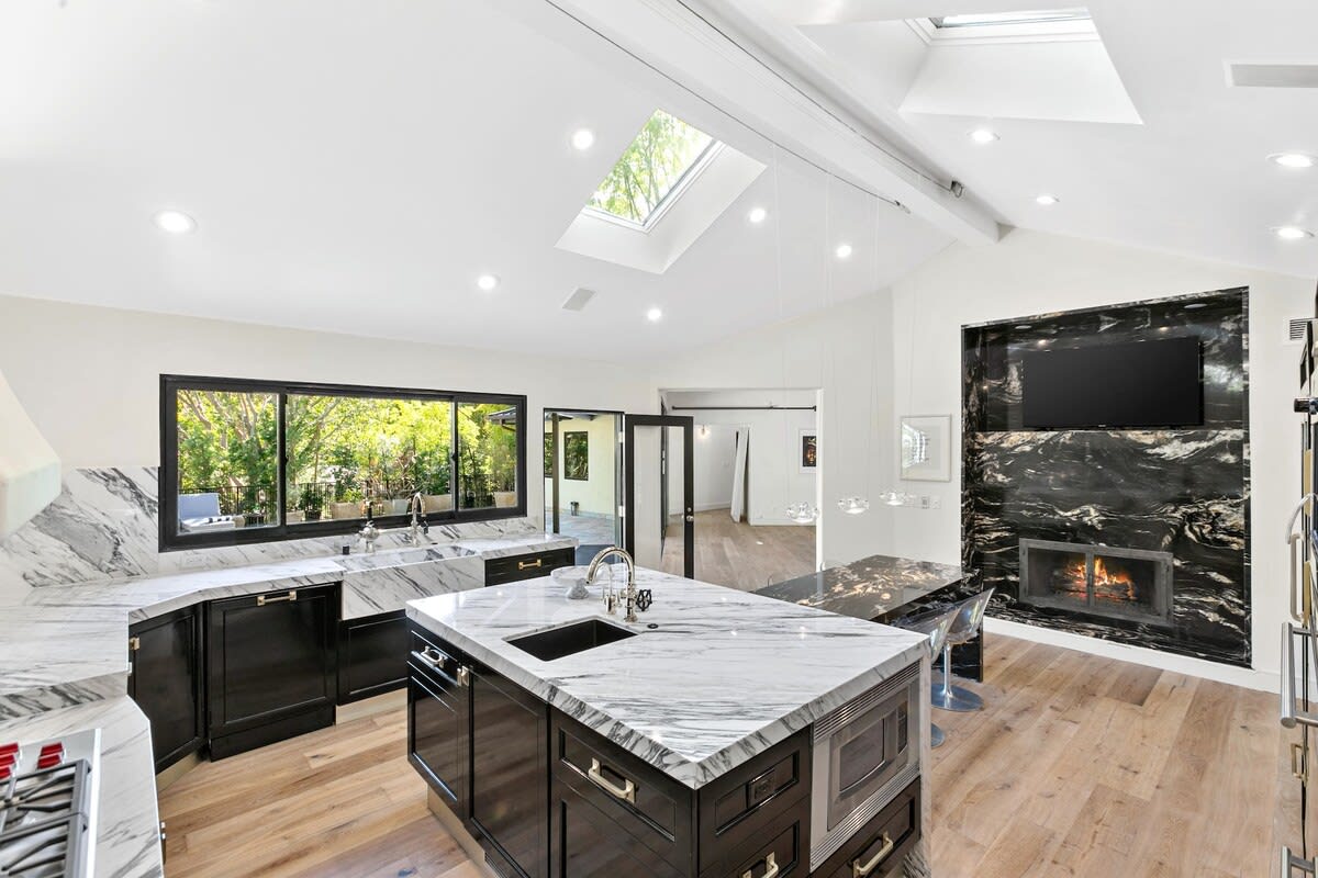 The kitchen has a TV to entertain family while cooking, and a fireplace for colder nights