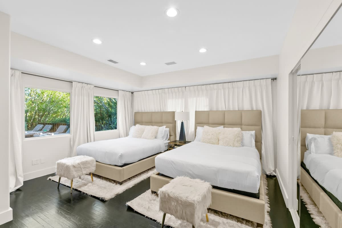 2 queen beds in guest bedroom and views of the outdoor pool area