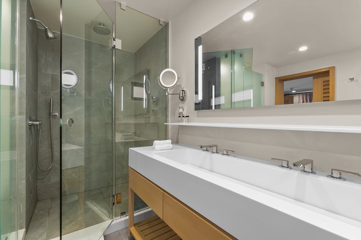 Modern, spa-style bathroom with all of your everyday essentials; hairdryer, slippers, luxurious towels, and Beekman toiletries