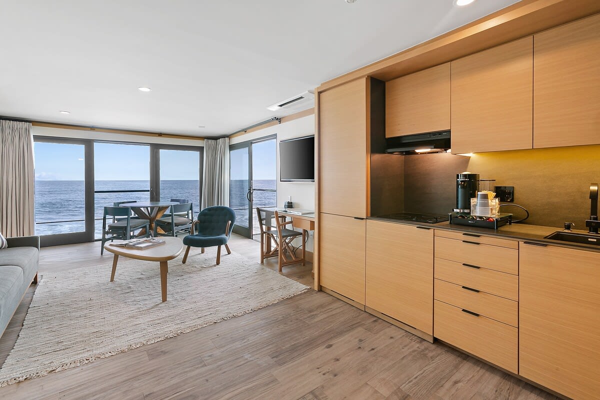 A kitchenette with mini-fridge and freezer, Broan cooktop fully stocked with drinkware, flatware, and dinnerware. A Nespresso Vertuo, coffee station with pods, Breville toaster oven, iron tea kettle and Ninja blender for preparing smoothies andlight meals