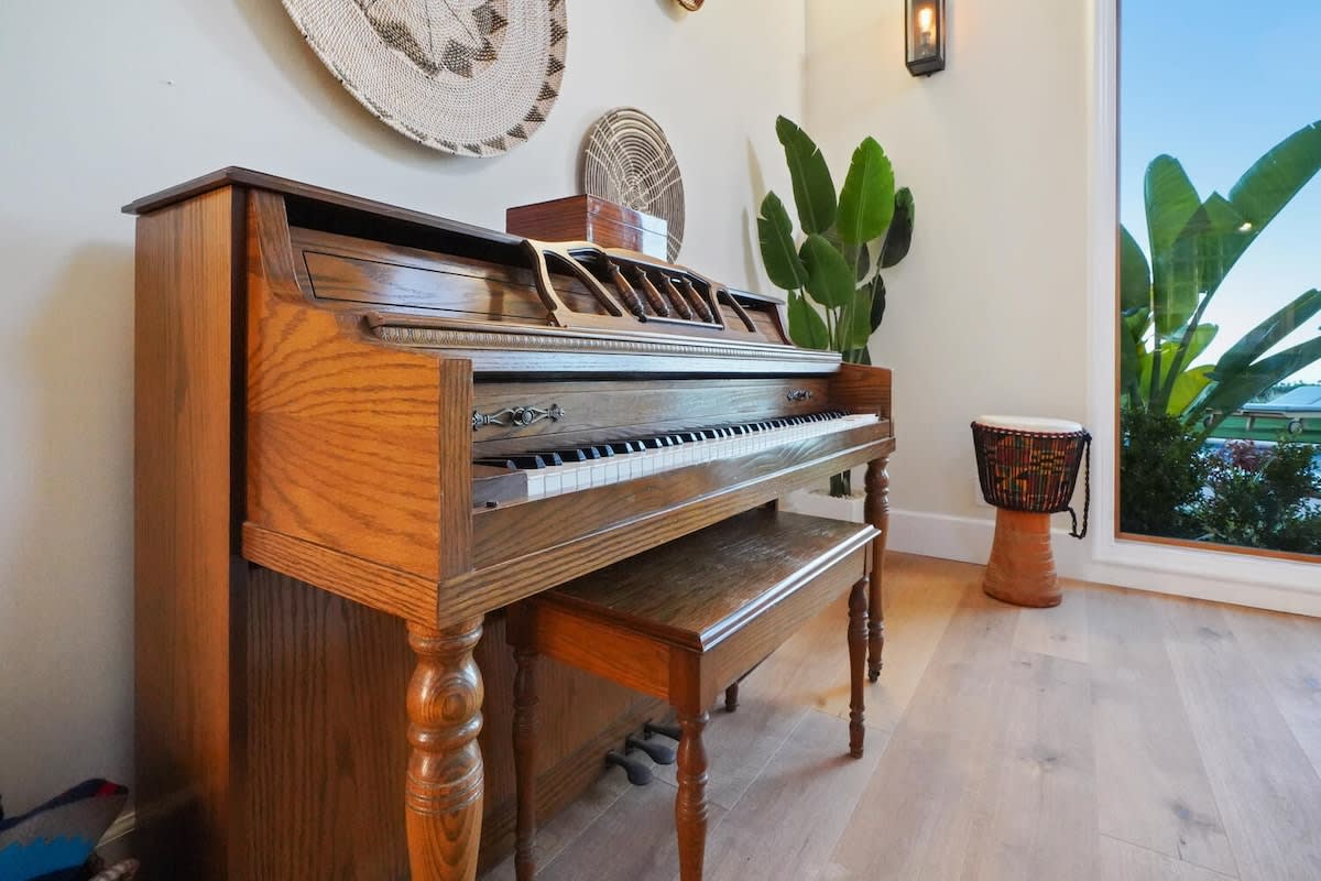 A wooden piano adds a touch of elegance to the space.