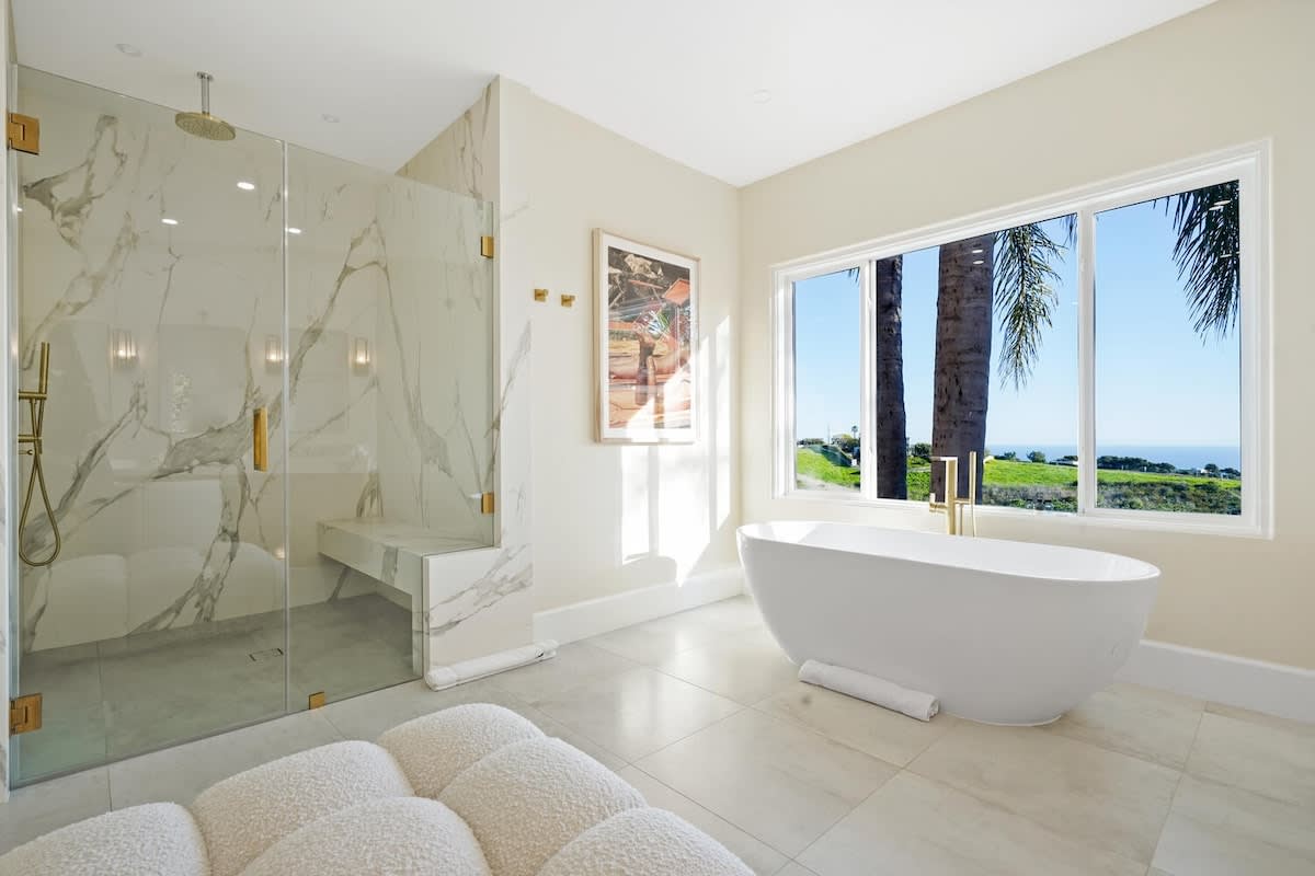 Relax in the spa-style master bathroom with a deep soaking tub and ocean vista.