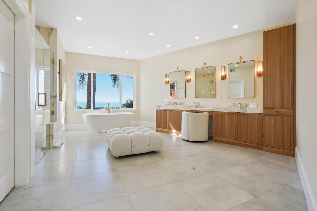 Master bathroom suite featuring large mirrors, dual sinks, and a powder area.