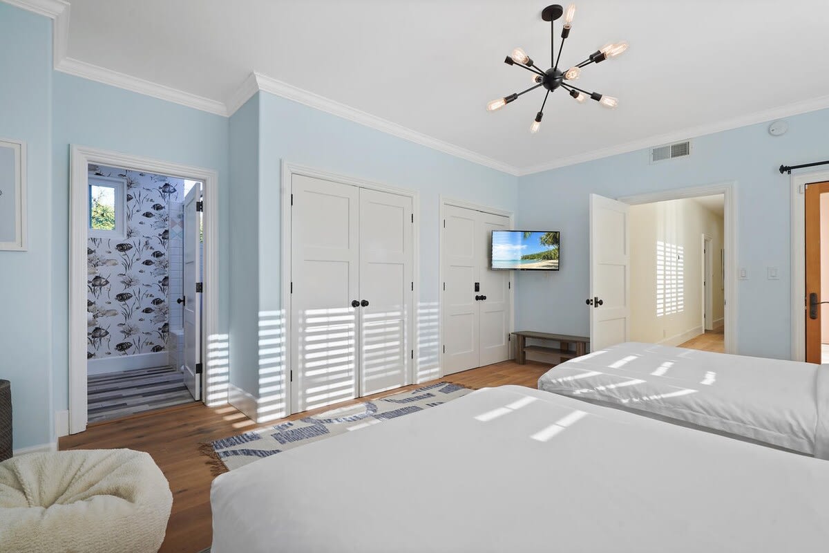 Guest bedroom with two twin beds and an en-suite bathroom space.