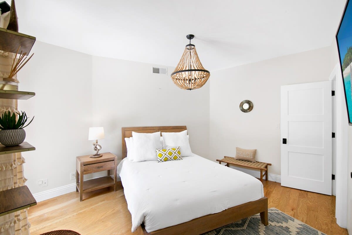 Guest bedroom with a queen sized bed lined with plush and clean sheets, ready for you to fall into.