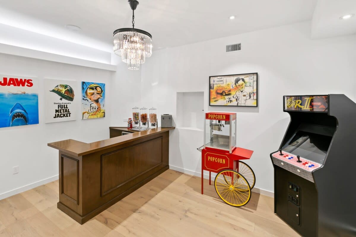Entertainment room with arcade game, popcorn maker, candy machines, and an extra flare of fun pop-culture artwork.