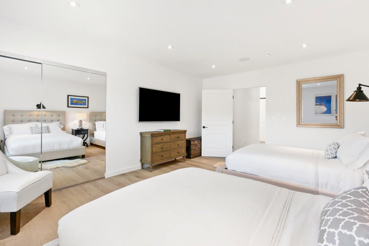 Guest bedroom with large mirrored closets and extra storage space for guests.