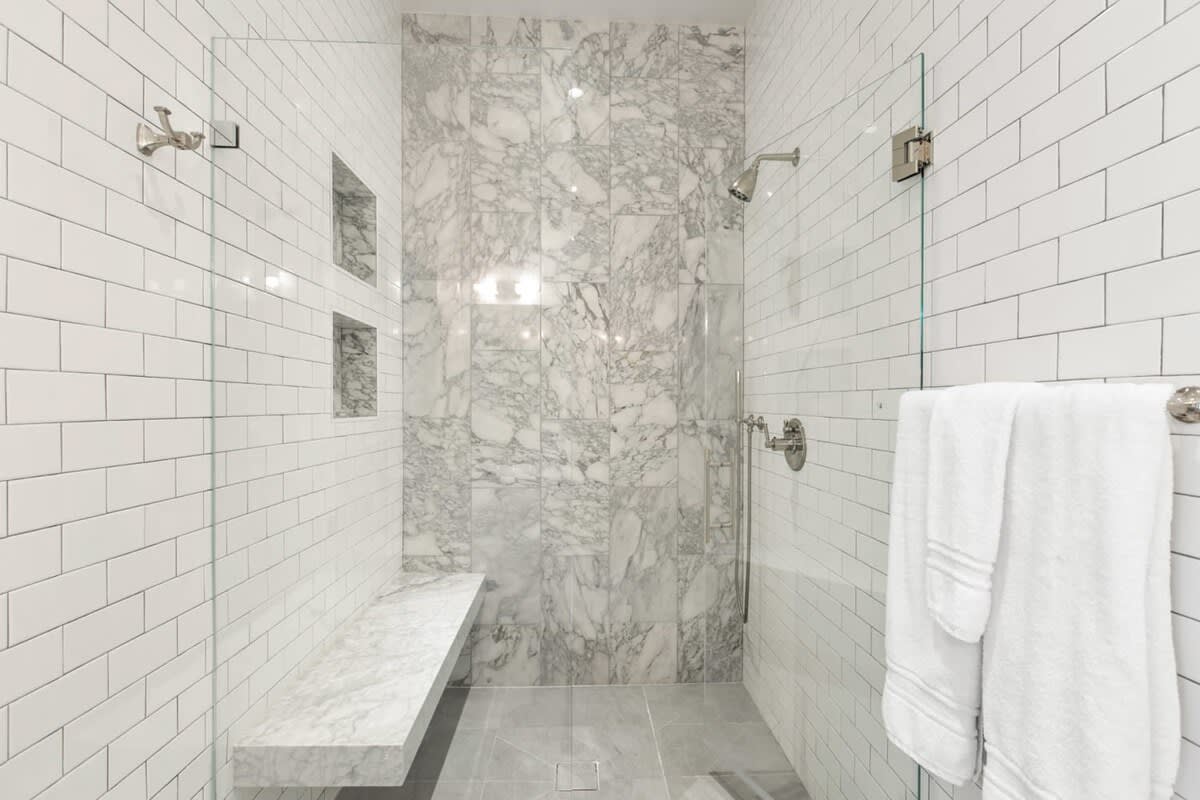 White marble and tile create a perfect backdrop for this rain shower.