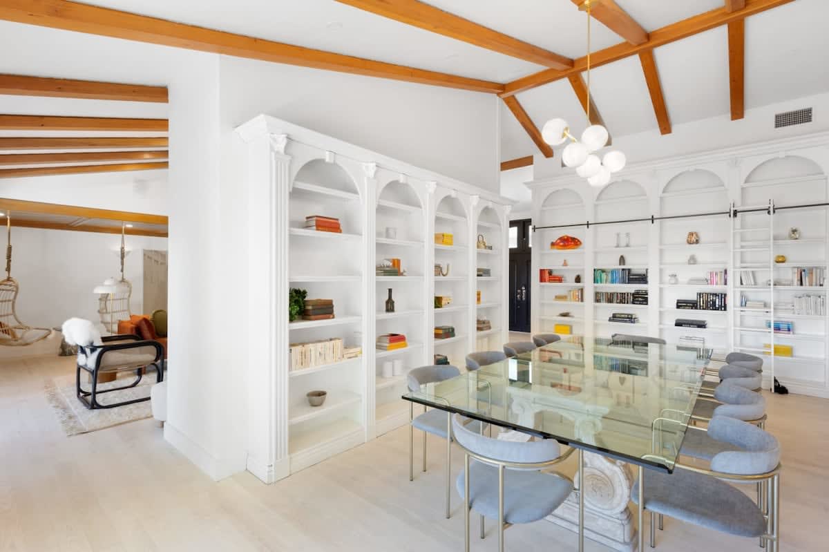 Vaulted, wood lined ceilings with a formal glass dining table and exquisite seating chairs.