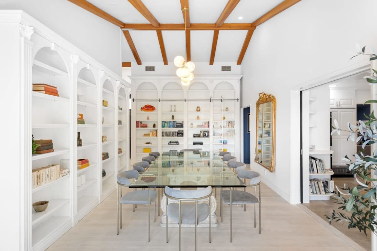 Formal dining area with a timeless design lined with books and unique art.