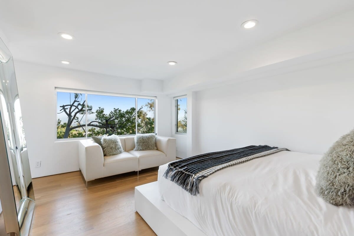 Guest Bedroom 1, with a comfortable sofa and large windows