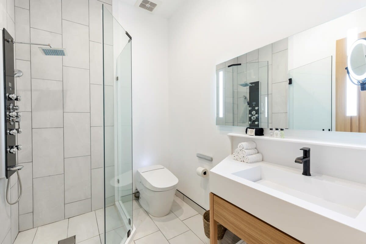LED lit vanity mirrors, Toto Neorest toilet and graft rain shower.