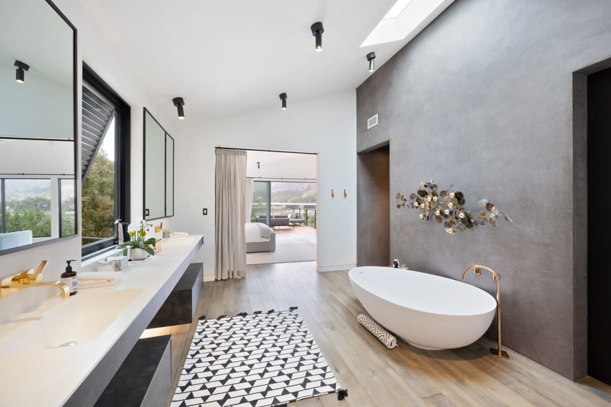 Enjoy a relaxing bubble bath while sipping on a glass of campaign in this luxurious bathroom.