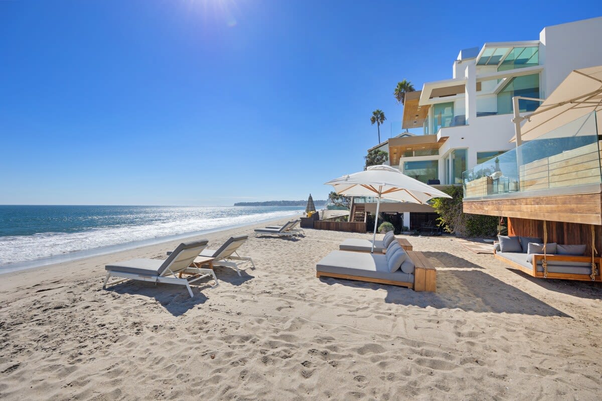 Luxurious beach sun loungers and outdoor umbrellas on the beach.