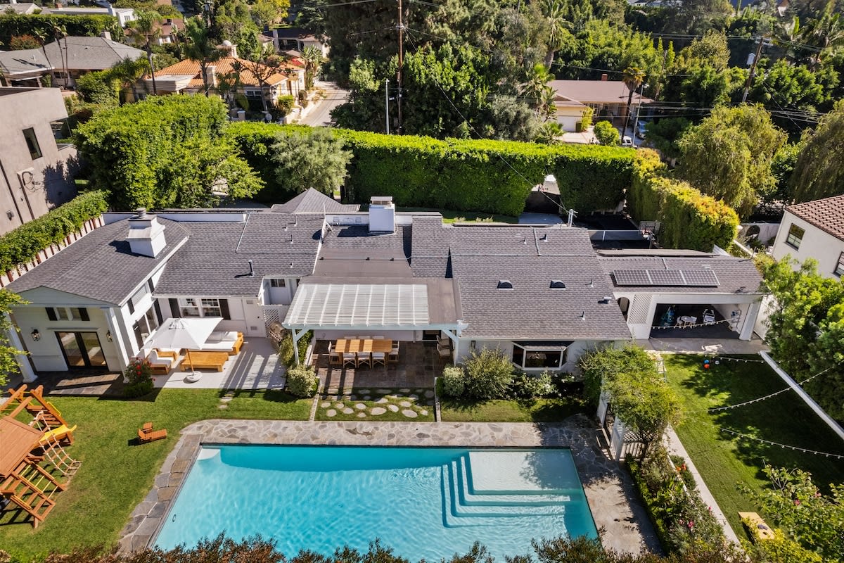 Immerse yourself in the lush outdoor living of this backyard, featuring a playground, patio, and a beautiful pool—ideal for families and relaxation.