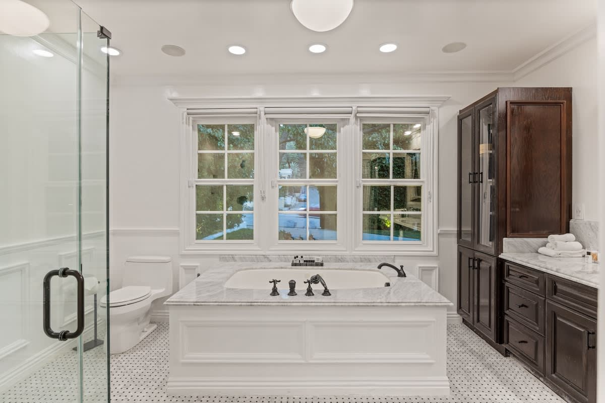 Treat yourself to a bathing extravaganza in this luxurious bathroom, boasting a deep soaking tub and captivating marble details.