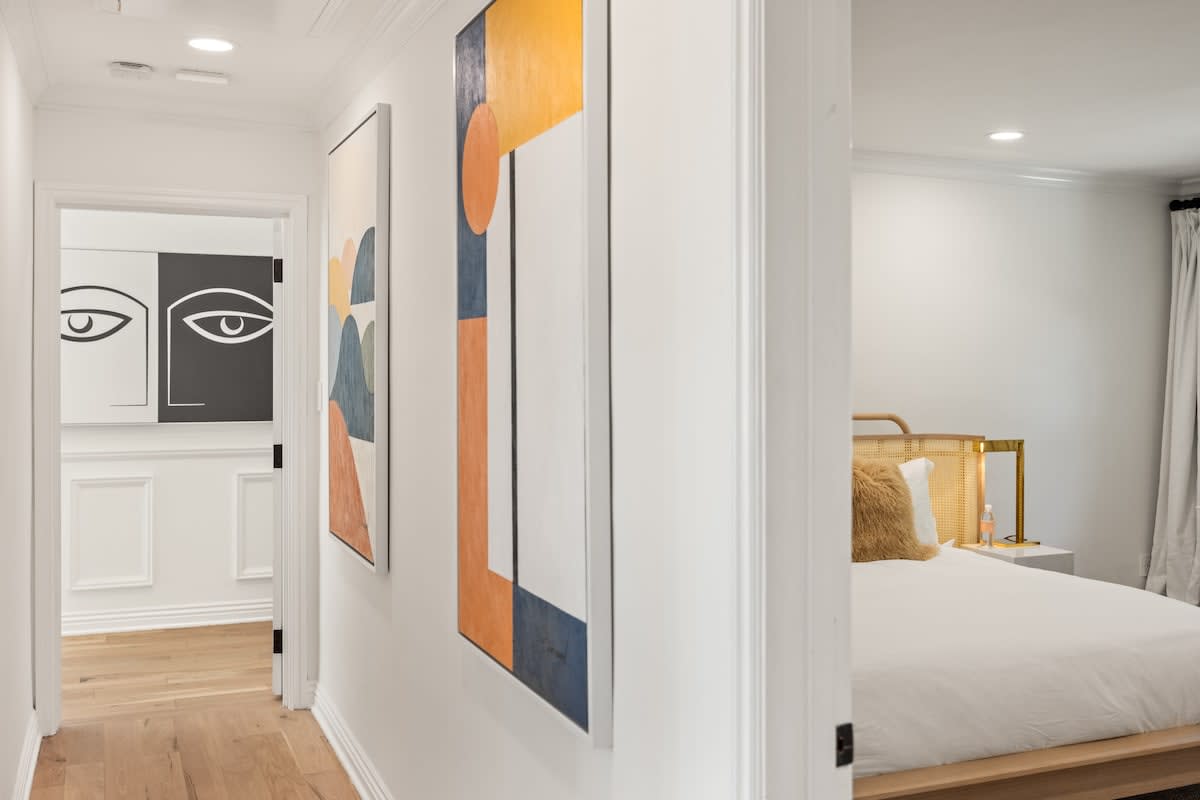 The art-lined hallway guides the way to bedrooms.