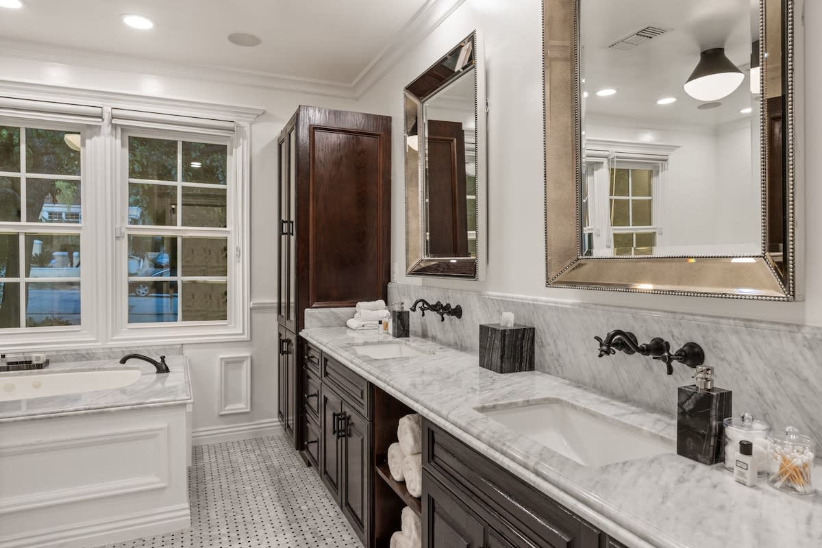 Revel in dual opulence with his and hers sinks in the bathroom, complemented by a lavish marble bathtub.