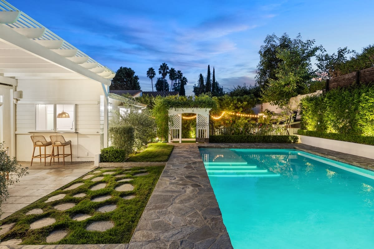 Experience an oasis at night with a refreshing pool and nearby garden—a perfect setting for relaxation under the stars.