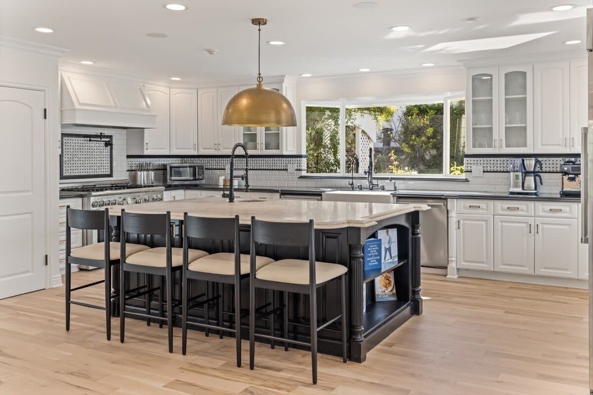 A spacious kitchen, complemented by 4 additional bar stools.