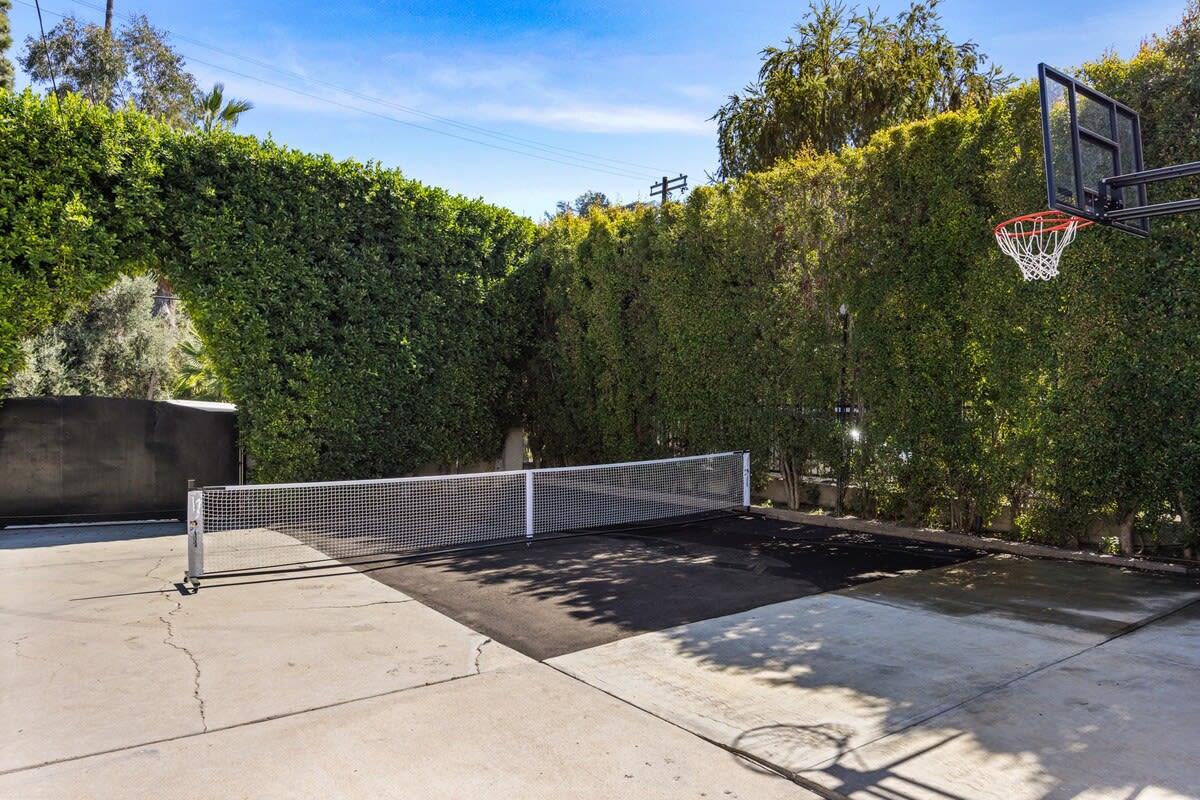 Step into a versatile play zone equipped with an extended tennis court and a basketball net.
