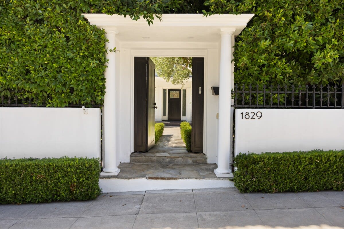 White pillars frame the grand entrance, guiding you along the luxurious walkway.