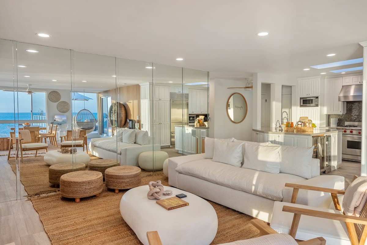 Reflect timeless elegance in the living room with a chic mirror wall at Aqualina.