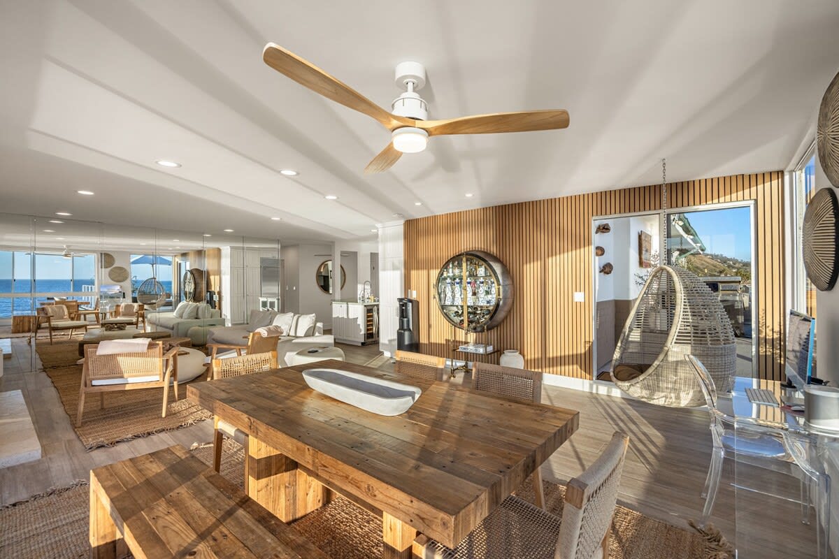 Entertain in a space where sculpted wood, boucle textures, and sea breezes define the mood.