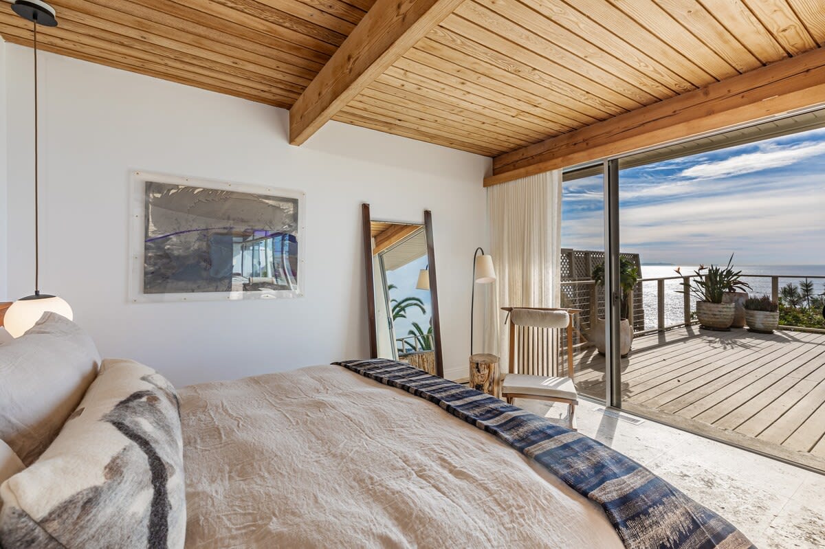 Bask in morning sunlight as it graces the bedroom, revealing a king-size bed and breathtaking ocean scenery.