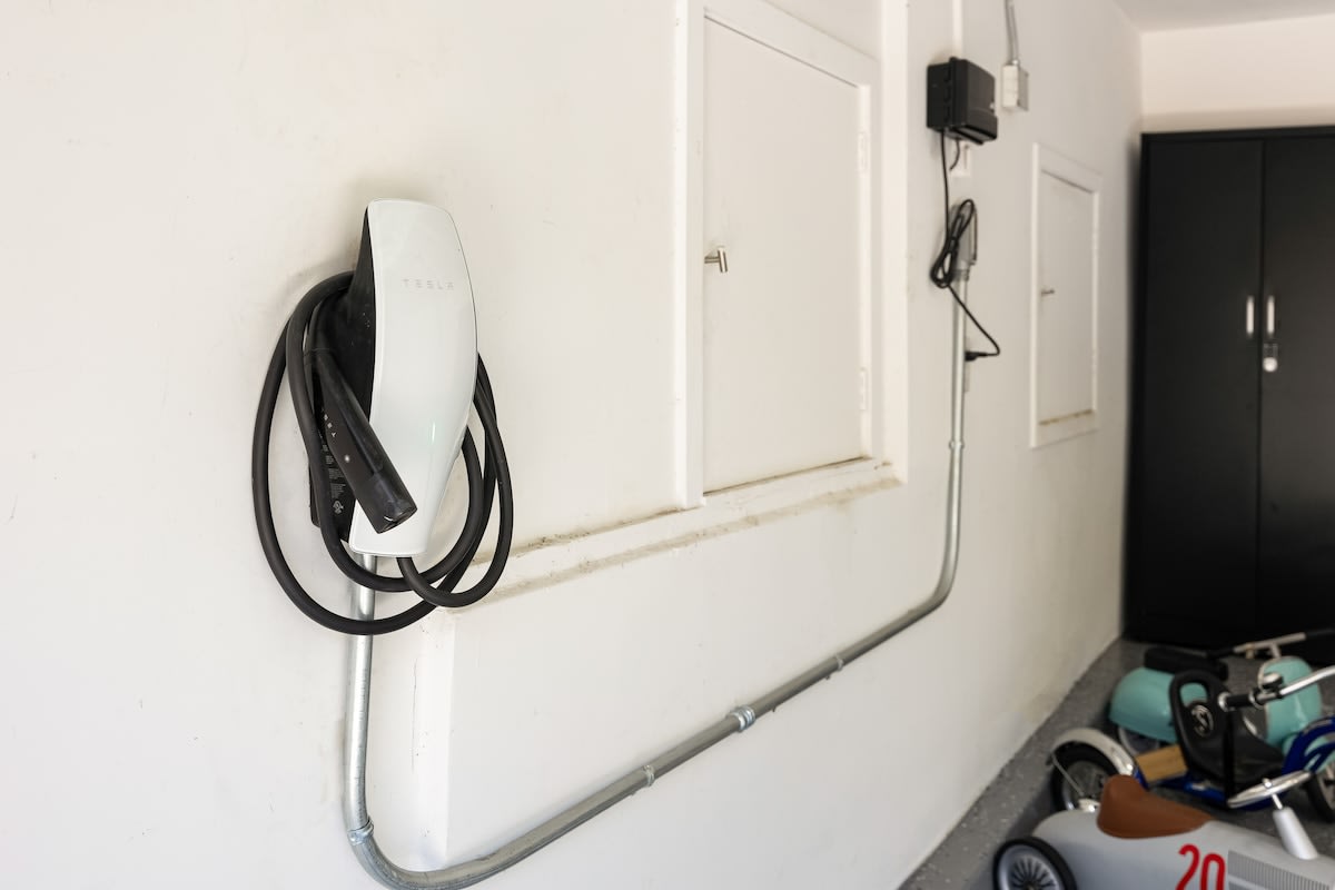 Charge your Tesla effortlessly with the convenient car charger in the garage.