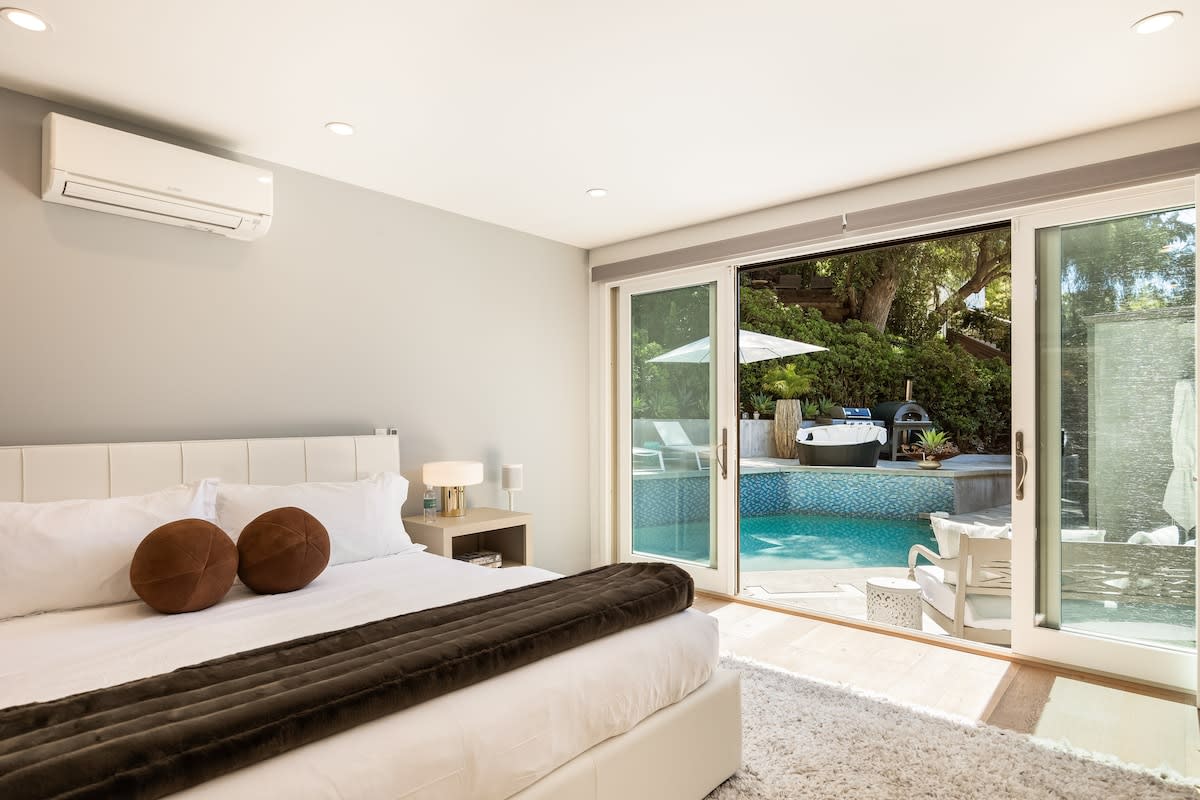 Step out from the bedroom through glass doors directly into the outdoor pool area, effortlessly merging indoor comfort with outdoor leisure.