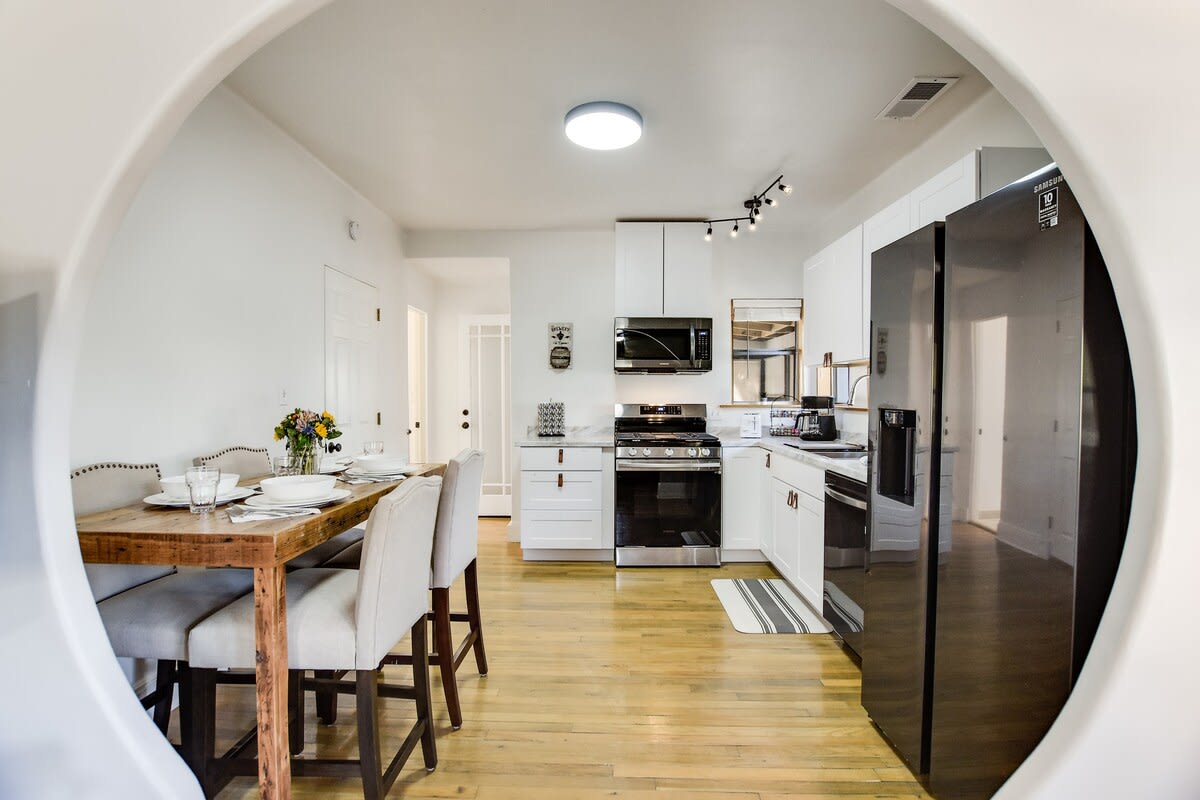 A view of the dining room and kitchen through the arched doorway.