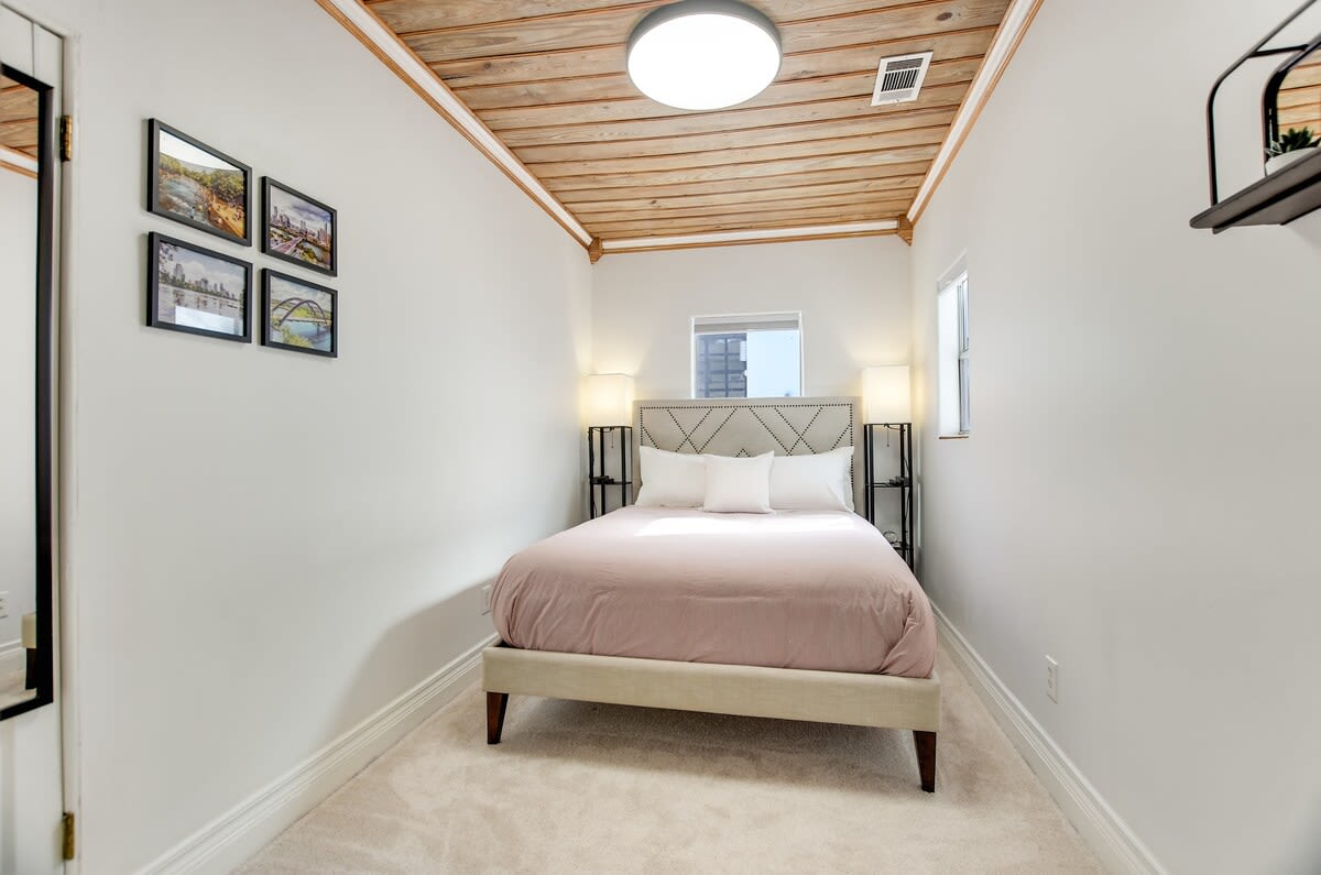 The second sleeping room features a queen bed and original wood soffit ceilings.