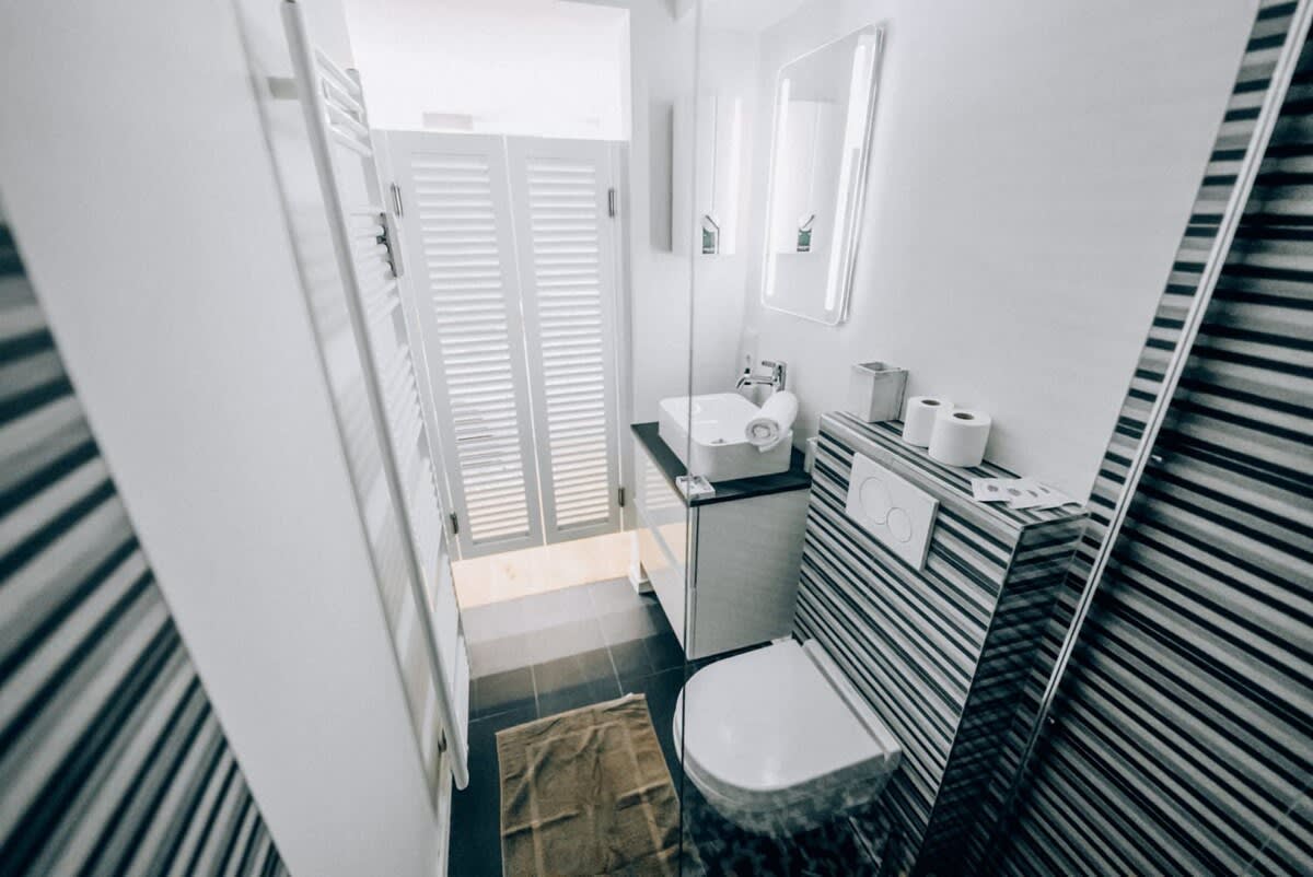 Bright and clean bathroom featuring contemporary fixtures and ample natural light, offering a comfortable space for your daily routines.